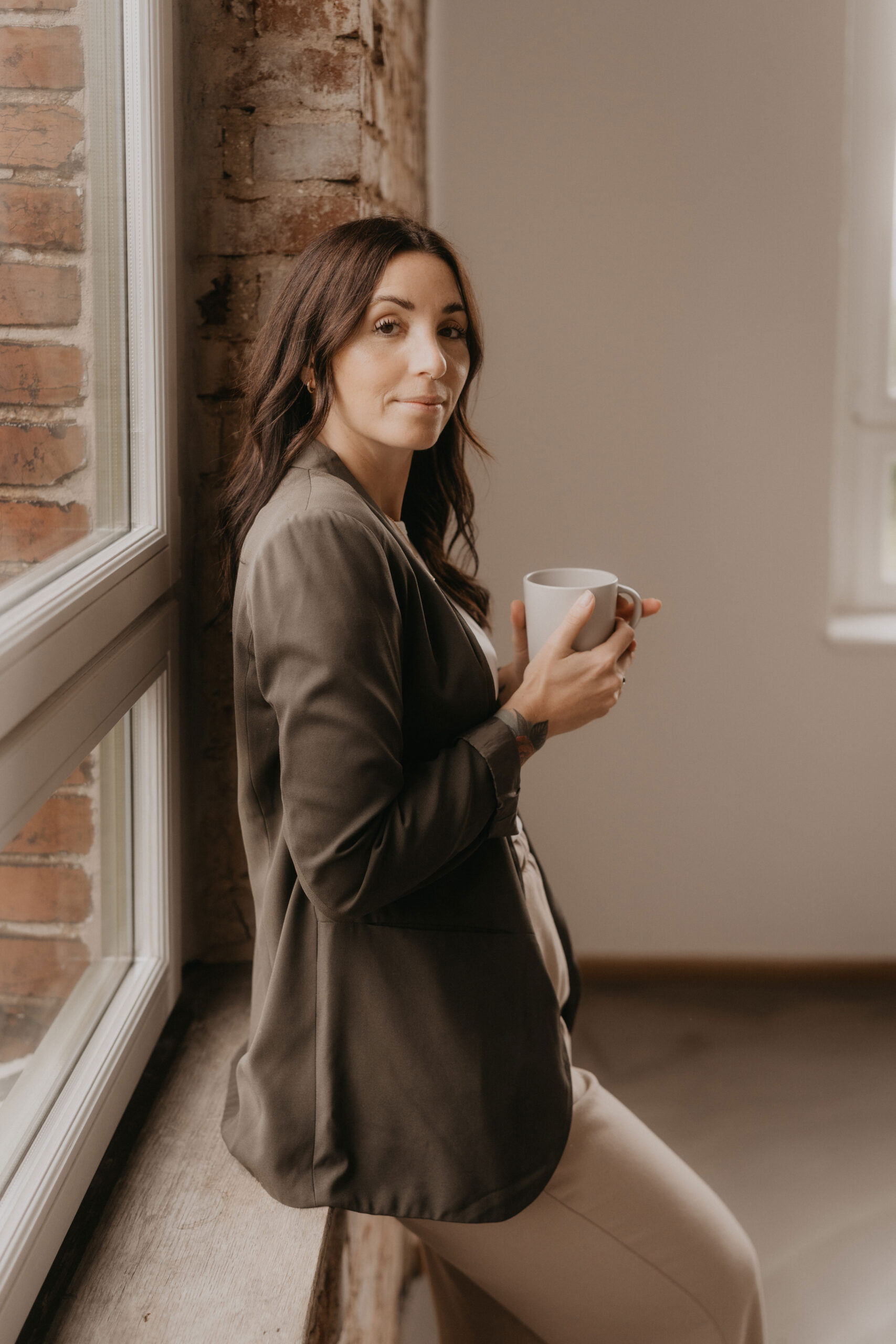 Teresa Fink mit Kaffeetasse an der Wand